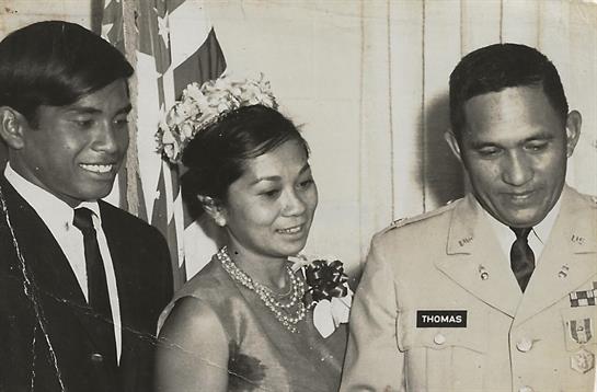 Three people chat at a formal event, highlighting their elegant outfits and accessories.