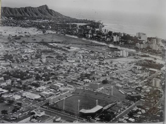 A bird's eye view captures Waikiki, featuring Diamond Head and the coastal city layout, circa 1960s.