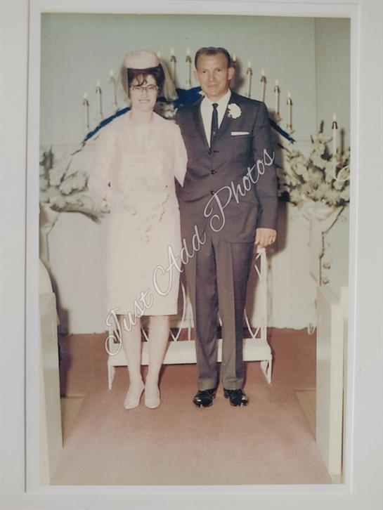 Newlyweds stand together at a floral-adorned venue during their wedding ceremony.