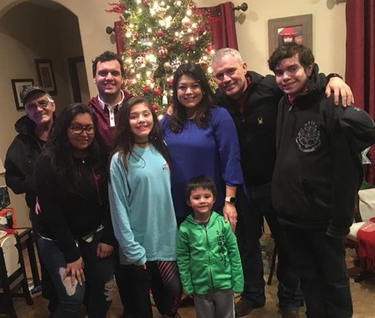 A joyful family poses together in a cozy living room, celebrating the holiday season.
