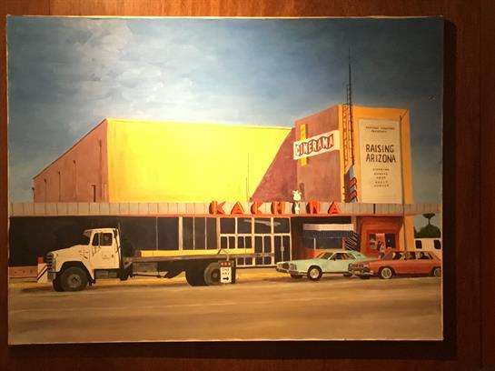 Large building features a striking yellow and purple design, surrounded by parked cars in Arizona.