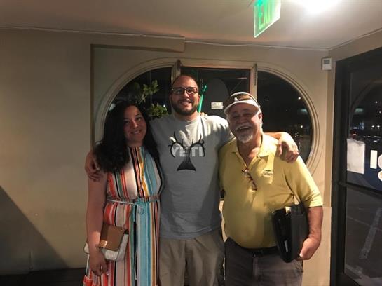 Three family members enjoy a cheerful reunion in a relaxed restaurant atmosphere.