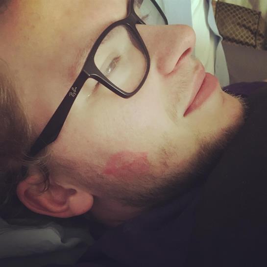 A person is lying comfortably with glasses, appearing relaxed in a cozy room setting.