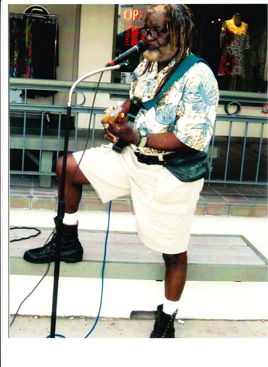 A talented musician captivates an audience with a guitar performance at a vibrant outdoor venue.