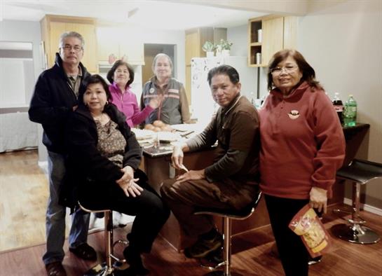 Group of friends enjoying each other's company in a warm kitchen, creating joyful memories together.