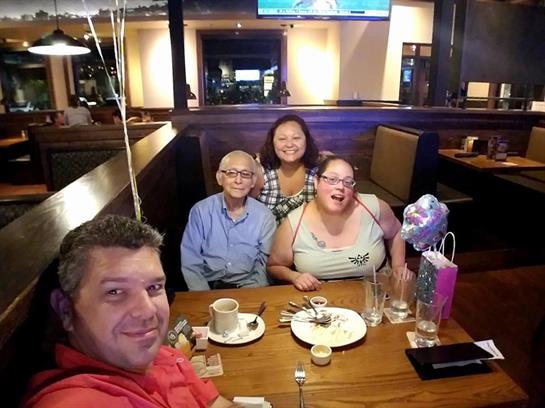 Friends laughing and dining happily in a cozy restaurant.
