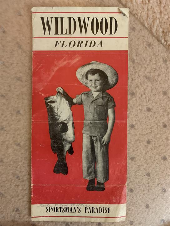 A young boy wearing a hat shows off a large fish, capturing a moment from Wildwood, Florida.