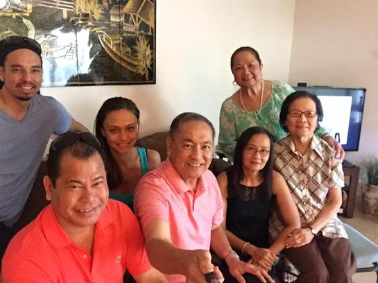 A group of friends enjoys each other's company, sharing smiles in a bright living room setting.