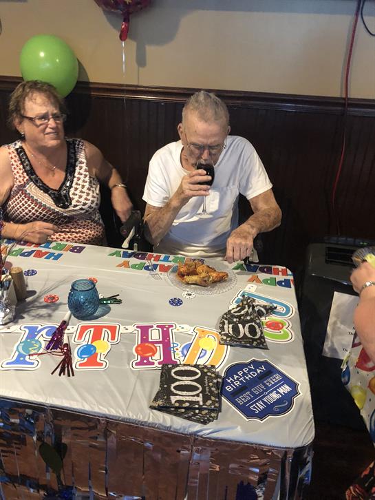 Guests celebrate a century of life with a festive gathering, food, and laughter.