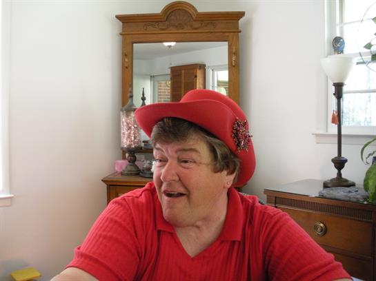 Individual smiles while engaging in conversation at a home interior featuring vintage decor.