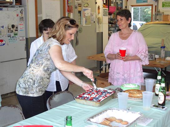 People celebrate together while sharing cake and drinks in a warm, inviting atmosphere.
