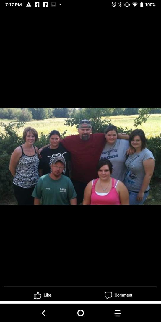 Friends enjoy a sunny afternoon together, smiling and posing in a beautiful green field.
