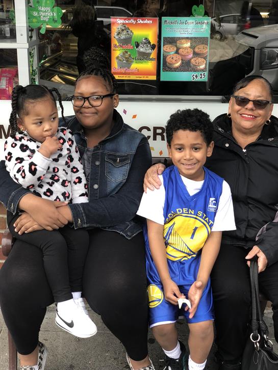A joyful family shares a moment enjoying ice cream at a food truck in the park.