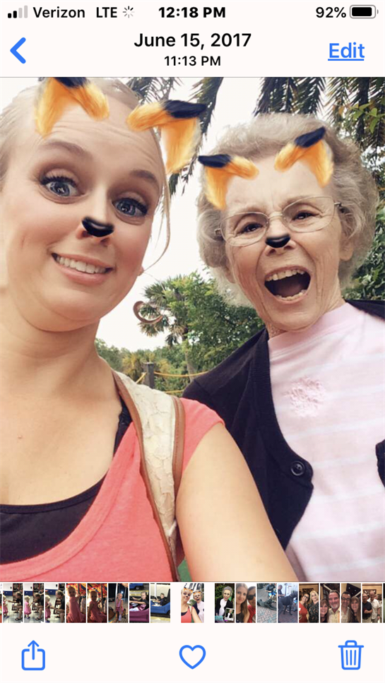 Two women enjoy a playful outdoor moment with animal filters on their faces.