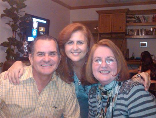 Three family members share smiles and warmth during an evening together at home.