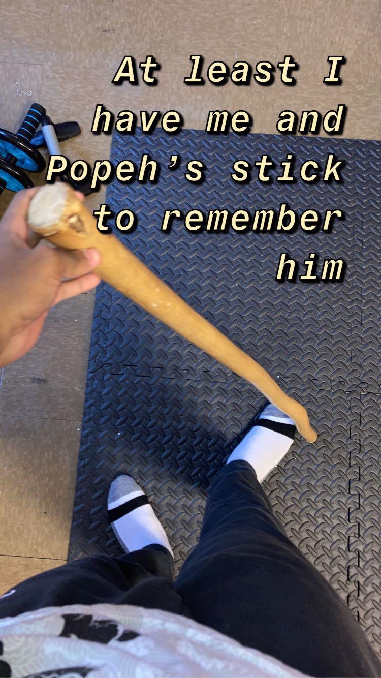 Holding a stick to honor a past connection while wearing sandals and socks.