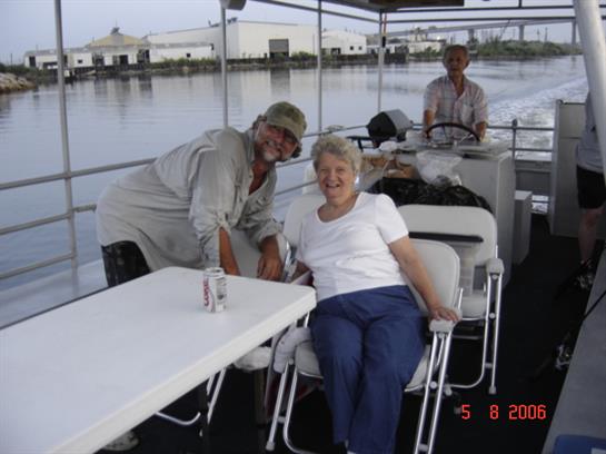 Friends relax on a boat, sharing smiles and laughter while enjoying the peaceful river view.