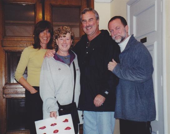 Four friends enjoy a warm evening together, sharing smiles and laughter in a cozy home setting.