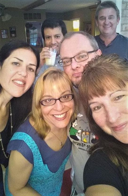 Friends gather and smile for a joyful group picture in a relaxed atmosphere, sharing laughs.