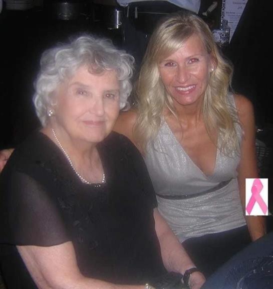 Two women share a moment at a community gathering, radiating warmth and joy in their smiles.