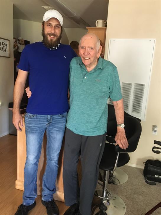Two men enjoy a joyful moment together in a care facility.