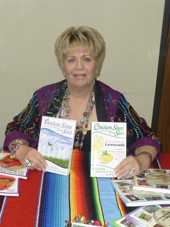 A cookbook author shares her new works and recipes at a local event, engaging with fans.