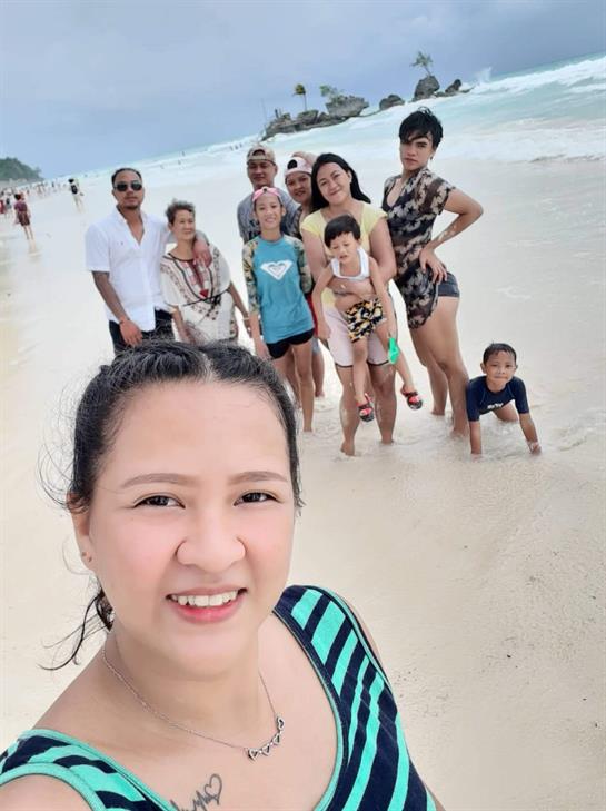 Group of family and friends relax and have fun on the beach, interacting and taking pictures.