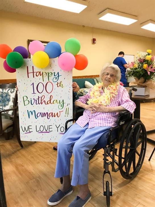 Family and friends gather to celebrate a special 100th birthday with decorations and love.