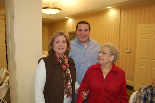 Three family members enjoy a cheerful moment together in a welcoming indoor environment.