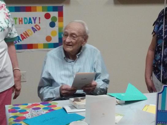 Family gathers to celebrate a birthday, sharing joy and laughter in a colorful setting.