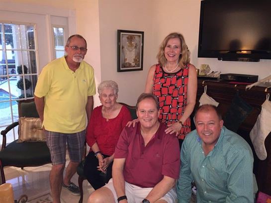 Five friends relax and enjoy each other's company in a warm, cheerful living room.