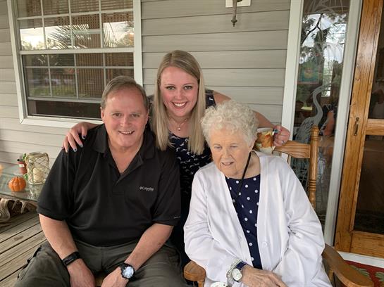 Family members enjoying time together on a porch, sharing joyful moments and smiles.