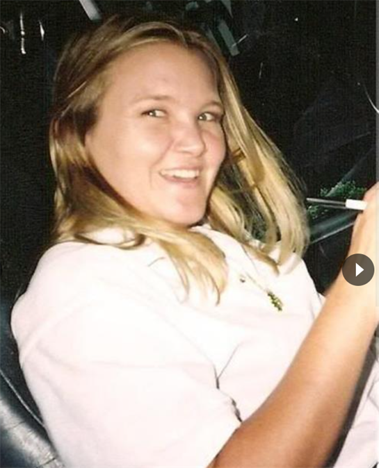 A cheerful young woman sits in a car with a pen in hand, enjoying her time outdoors.