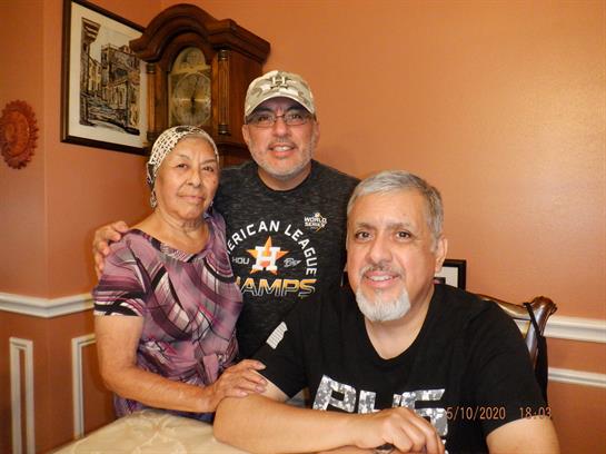 Three family members smile together, enjoying quality time in a welcoming home environment.