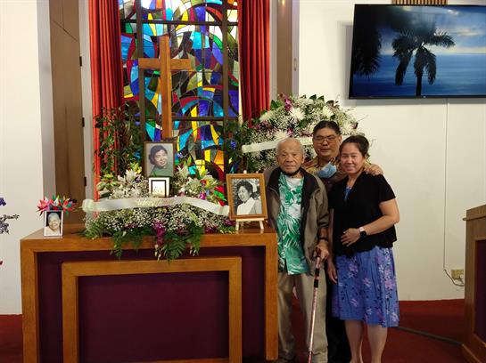 Family members gather together to commemorate a loved one surrounded by flowers and memories.