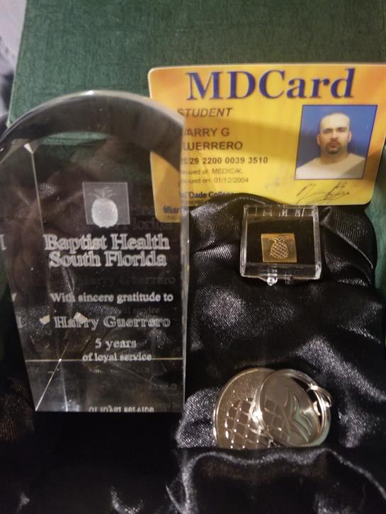 A recognition award, student ID, and a medallion are displayed together, showcasing achievements.