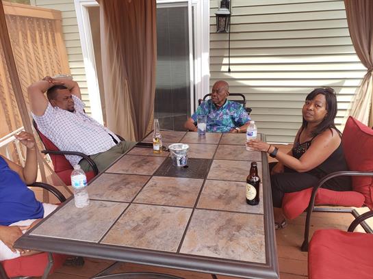 Friends enjoy each other's company on a cozy patio, sipping drinks and sharing stories in summer.