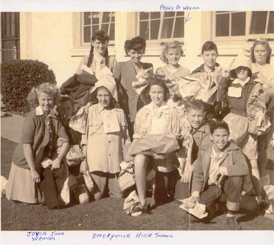 Schoolchildren smile and gather in front of their school building, showcasing joy and camaraderie.