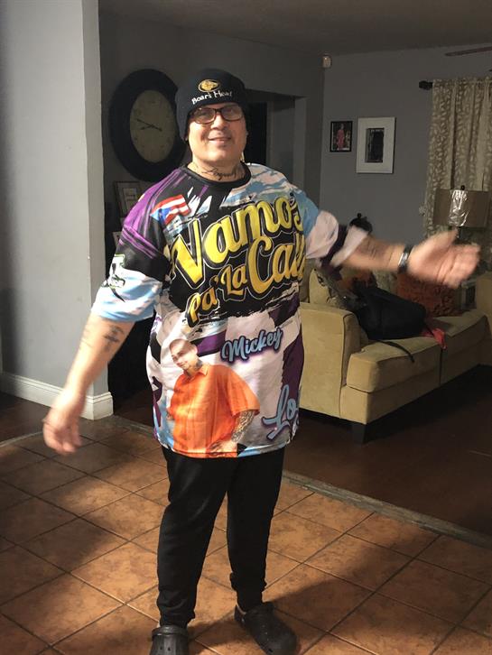 A cheerful man in a bright shirt relaxes with friends in a cozy living room.