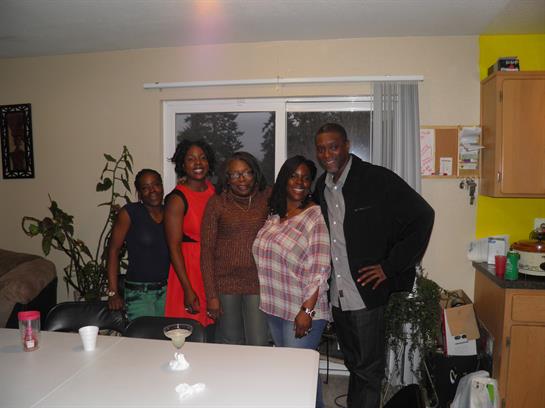 Five friends enjoy quality time together in a warm, inviting living room filled with plants.