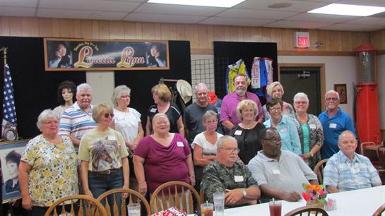 A lively gathering of friends at a reunion, sharing laughs and memories in a warm setting.