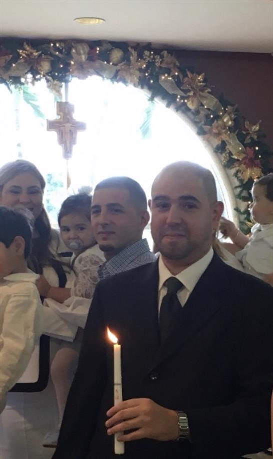 A family celebrates a religious event with children holding candles in a lovely church.