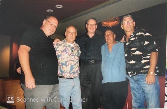Five men posed together in a relaxed atmosphere, sharing smiles and camaraderie during the night.