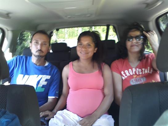 Three adults relax inside a car while enjoying a road trip during the day.