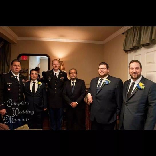 Groomsmen in formal wear pose together in an intimate setting before the wedding.
