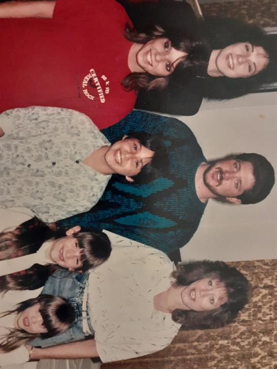 Family members pose together indoors, enjoying a cheerful moment filled with laughter and joy.