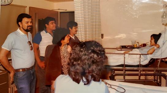 Several people interact in a warm living room filled with a relaxed atmosphere during evening hours.