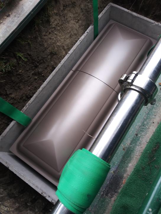 Heavy machinery is positioned over a waterproofing application area at the construction site.