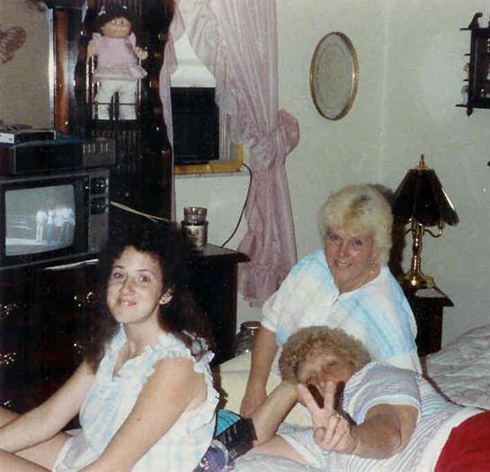 Three friends relax and enjoy each other's company in a comfortable room filled with nostalgia.