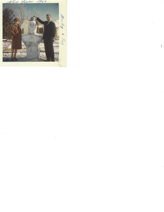 A couple strolls hand in hand along a cobblestone path surrounded by charming buildings.